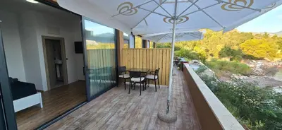 a balcony with a table and chairs and an umbrella at Beachfront Blue Panorama in Bar