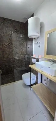 a bathroom with a toilet and a sink and a shower at Beachfront Blue Panorama in Bar