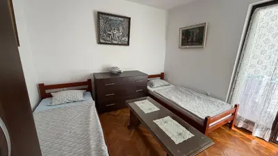 a room with two beds and a table in it at Laurel Apartment See View in Budva