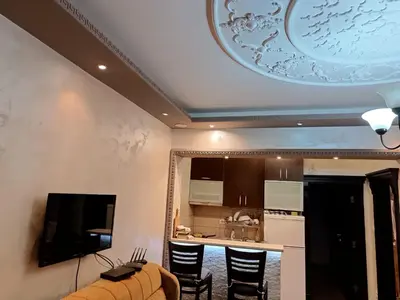 a living room with a kitchen with a ceiling at Martina Apartmani in Budva