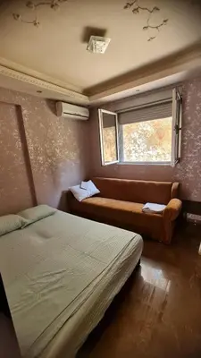 a bedroom with a bed and a couch and a window at Martina Apartmani in Budva
