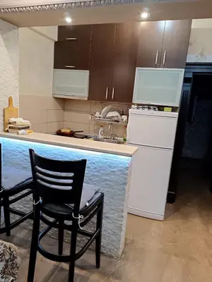 a kitchen with a counter and two chairs and a counter top at Martina Apartmani in Budva