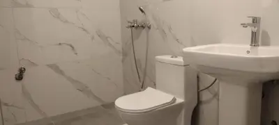 a white bathroom with a toilet and a sink at Apartments Arb in Ulcinj