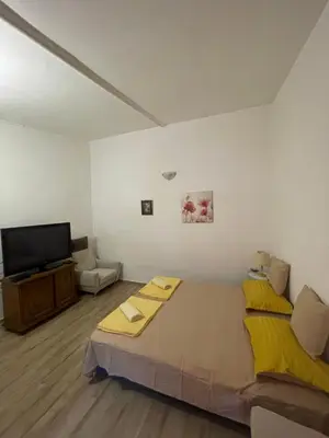 a bedroom with a large bed and a flat screen tv at Maric in Tuzi