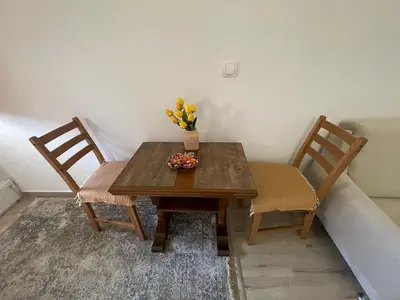 a wooden table with two chairs and a vase of flowers on it at Maric in Tuzi