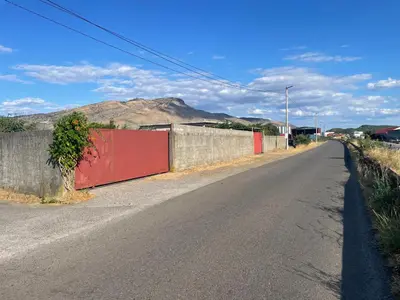 an empty street with a fence and a road at Maric in Tuzi