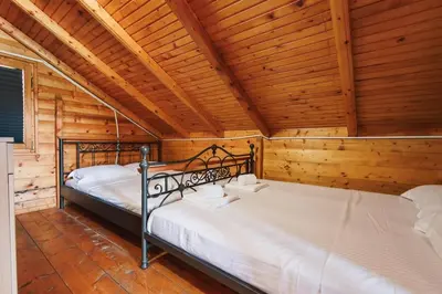 two beds in a room with wooden walls at Casa Tiramisù in Ulcinj