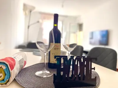 a bottle of wine and two glasses on a table at Cozy city apartment Podgorica in Podgorica