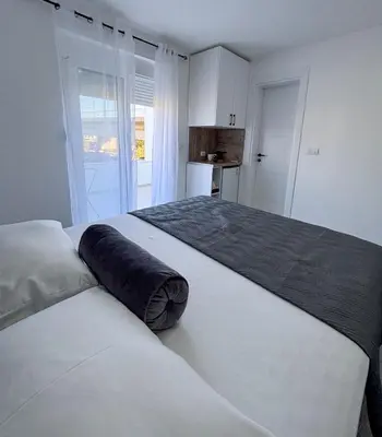 a bedroom with a large bed with a pillow on it at Harasani apartments in Ulcinj