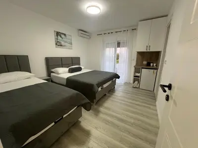 a hotel room with two beds and a kitchen at Harasani apartments in Ulcinj