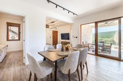 a dining room with a table and chairs at Skyline Residences in Bigovo