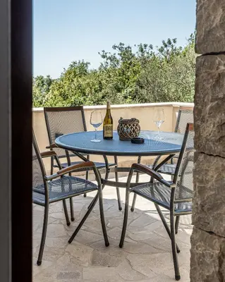 a table with two wine glasses on a patio at Skyline Residences in Bigovo
