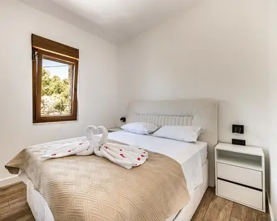a bedroom with a bed with a bow on it at Skyline Residences in Bigovo
