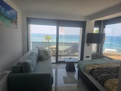 a living room with a couch and a view of the ocean at Apartmani Mali Pijesak in Dobra Voda