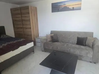 a living room with a couch and a bed at Apartmani Mali Pijesak in Dobra Voda