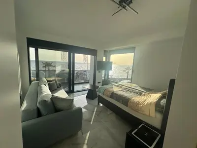 a bedroom with a bed and a couch and windows at Apartmani Mali Pijesak in Dobra Voda