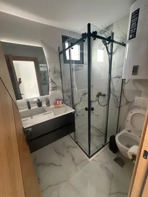 a bathroom with a shower and a sink and a toilet at Apartmani Mali Pijesak in Dobra Voda