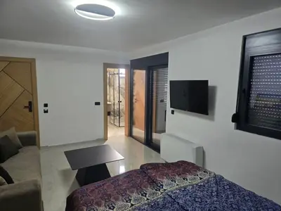 a bedroom with a bed and a tv on the wall at Apartmani Mali Pijesak in Dobra Voda