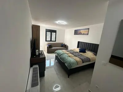 a bedroom with a bed and a couch at Apartmani Mali Pijesak in Dobra Voda