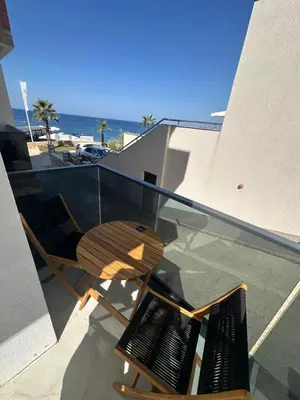 a wooden chair sitting on top of a glass balcony at Apartmani Mali Pijesak in Dobra Voda