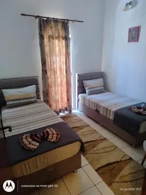 two beds sitting in a room with a window at Apartman V,P in Sutomore