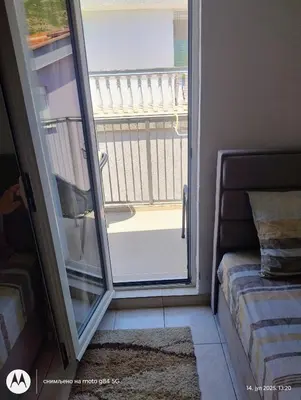 a room with a sliding glass door with a balcony at Apartman V,P in Sutomore