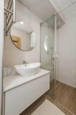 a white bathroom with a sink and a mirror at Autentica Apart in Cetinje
