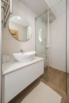 a white bathroom with a sink and a mirror at Autentica Apart in Cetinje