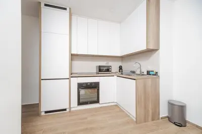 a kitchen with white cabinets and a sink at Autentica Apart in Cetinje