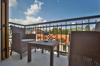 a patio with a table and chairs on a balcony at Autentica Apart in Cetinje