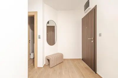 a hallway with a round mirror and a stool at Autentica Apart in Cetinje