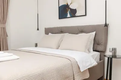 a white bedroom with a bed with white bedding at Autentica Apart in Cetinje