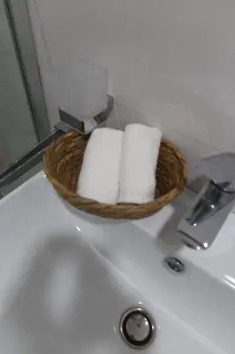 a basket of towels sitting on top of a bathroom sink at Apartment 82 Central Point in Podgorica