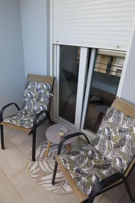 a living room with two chairs and a window at Apartment 82 Central Point in Podgorica