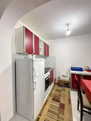 a kitchen with red cabinets and a white refrigerator at Ivan's Apartment in Budva in Budva