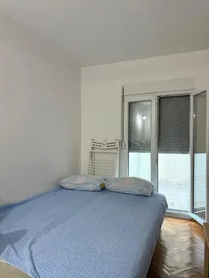 a bed with two pillows in a room with a window at Ivan's Apartment in Budva in Budva