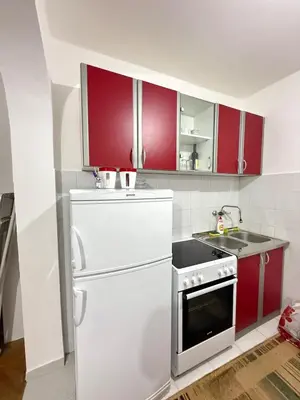 a kitchen with red cabinets and a white refrigerator at Ivan's Apartment in Budva in Budva