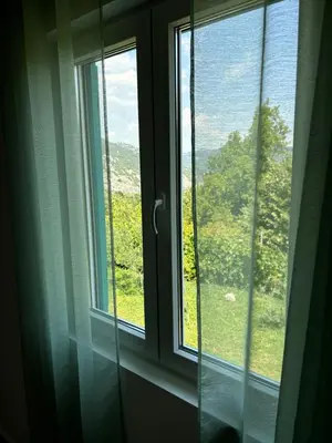 a window with a view of a green field at Deaf Valley Apartment 1 in Reljići