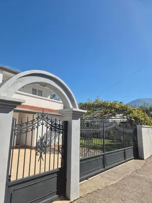 a gate to a house with an archway at Hayal Apartment in Bar