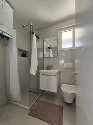 a bathroom with a toilet and a sink and a shower at Hayal Apartment in Bar