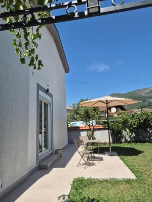a patio with a table and an umbrella at Hayal Apartment in Bar