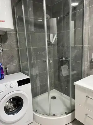 a shower with a washing machine in a bathroom at Amber Sky Apartments in Bjeliši
