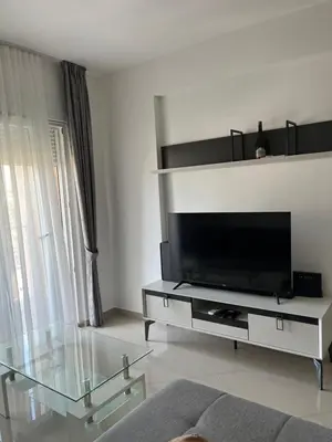 a living room with a television and a glass table at Amber Sky Apartments in Bjeliši