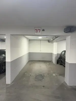 a parking garage with two cars parked in it at Amber Sky Apartments in Bjeliši