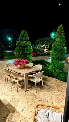 a table and chairs with flowers on a patio at night at Villa Doda - Donji Stoj - Ulcinj in Ulcinj