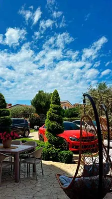 a patio with a table and chairs and a red car at Villa Doda - Donji Stoj - Ulcinj in Ulcinj