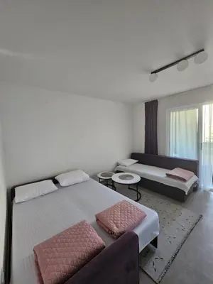 a bedroom with two beds and a couch at Rozino Budva in Budva