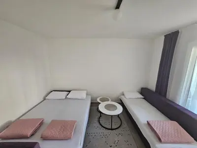a small room with two beds and a table at Rozino Budva in Budva