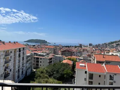 a view of a city with buildings and the ocean at MBv Budva in Budva