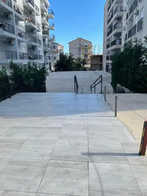 an empty sidewalk in a city with apartment buildings at MBv Budva in Budva